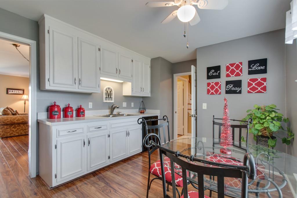 951 General George Patton Road Nashville, TN 37221 - Photo 12 of 25 a kitchen with stainless steel appliances granite countertop a refrigerator a sink dishwasher a dining table and chairs with wooden floor