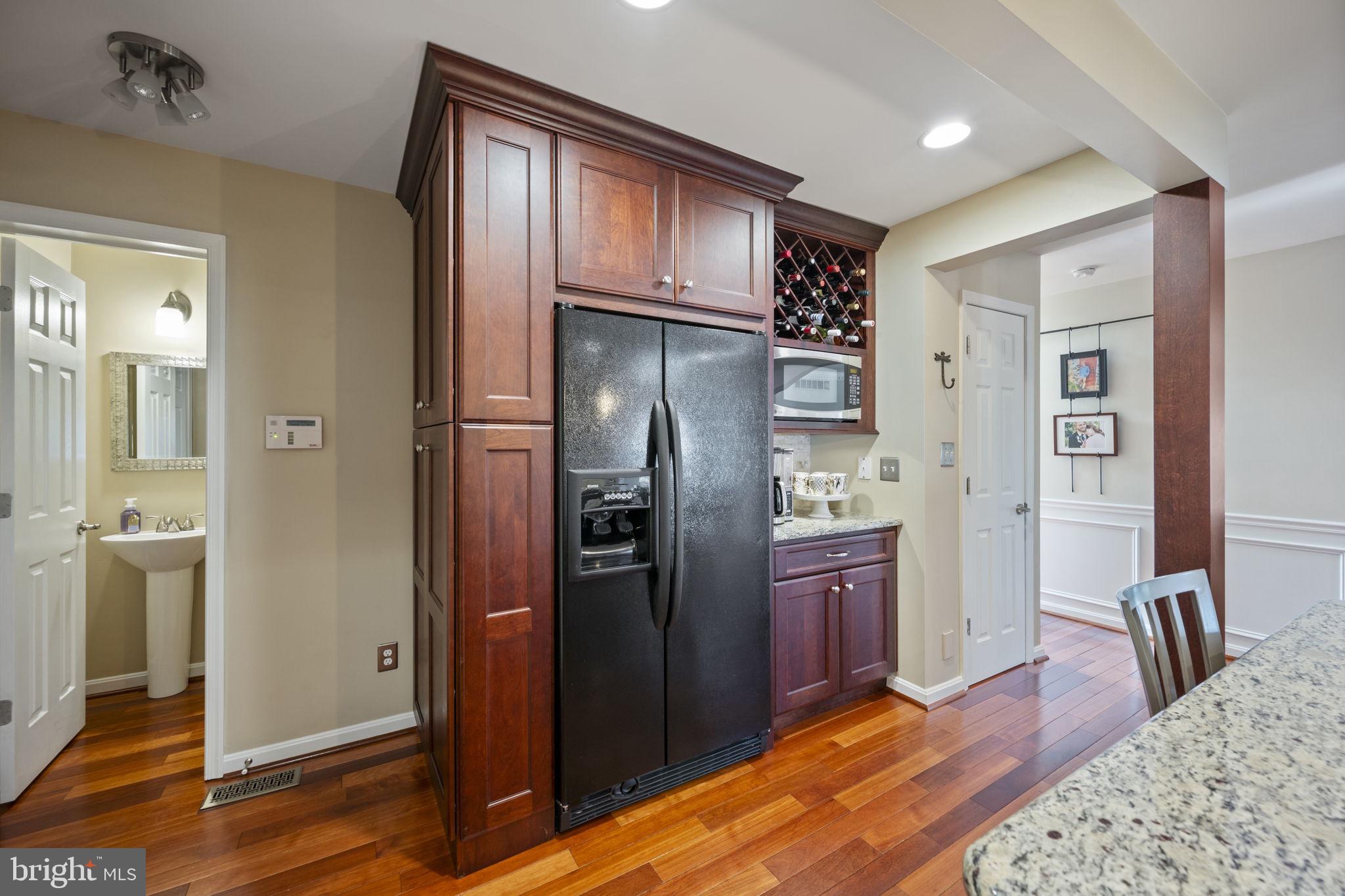 4310 Necker Avenue Nottingham, MD 21236 - Photo 15 of 56 a kitchen with stainless steel appliances granite countertop a refrigerator and wooden cabinets