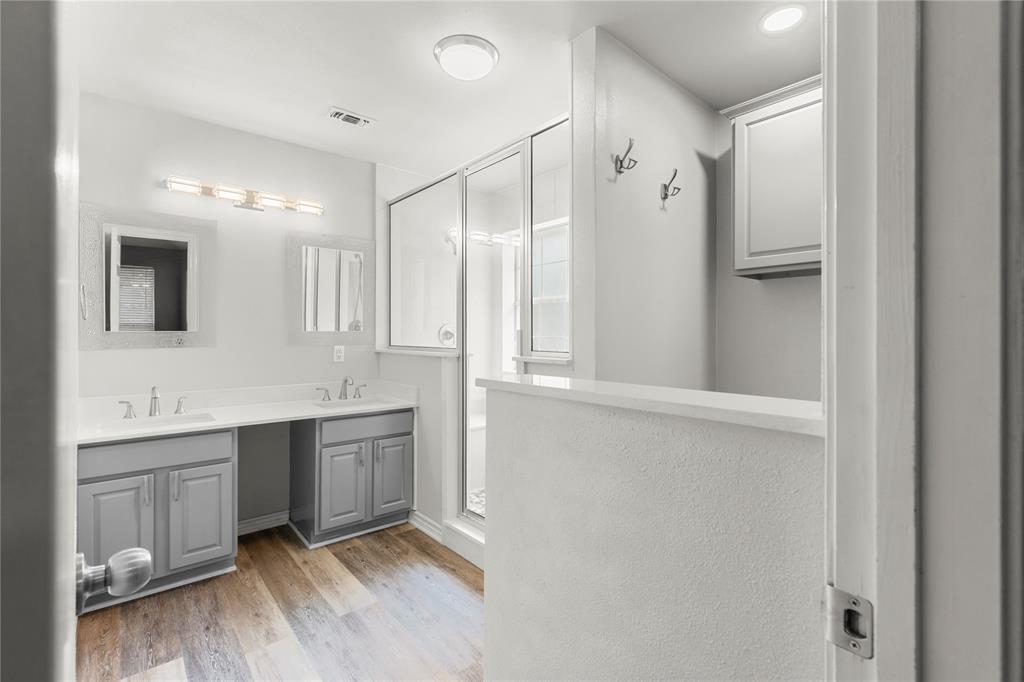 2917 Harlow Road Commerce, TX 75428 - Photo 15 of 40 a large bathroom with a double vanity sink a large mirror and a shower