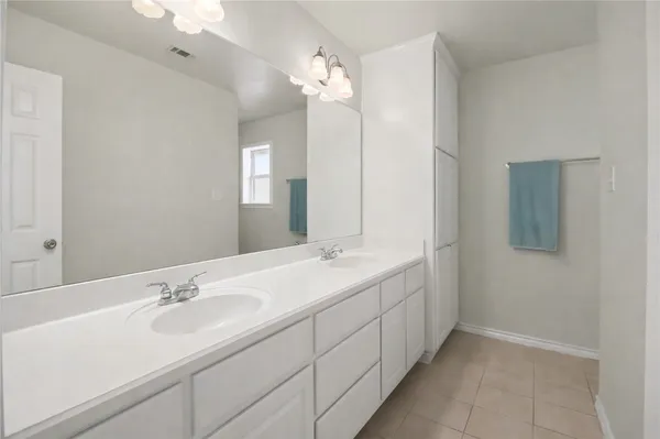 a bathroom with double sink and a mirror