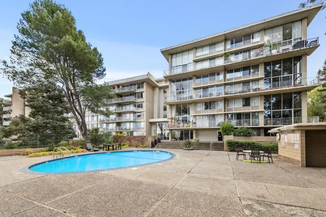 a view of pool with outdoor seating and city view