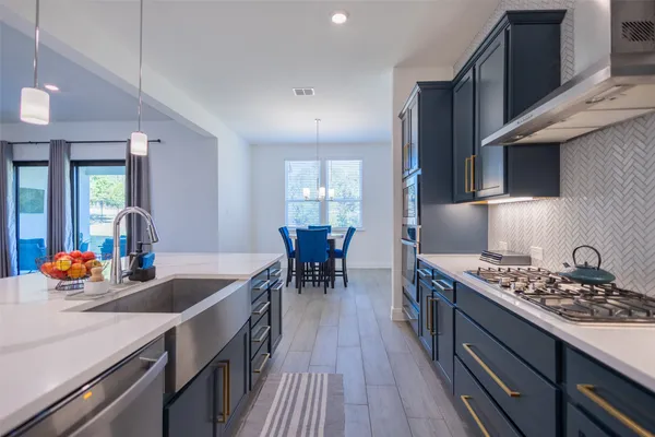 a kitchen with stainless steel appliances granite countertop a stove a sink and a refrigerator