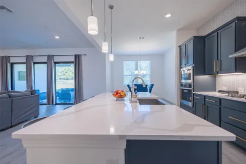 a large kitchen with stainless steel appliances a large counter top