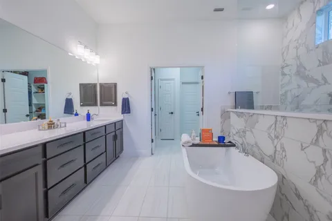 a bathroom with a tub sink and mirror