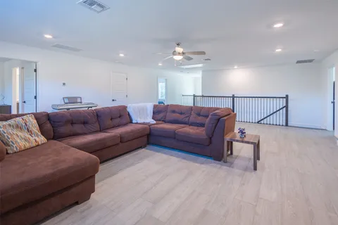 a living room with furniture a ceiling fan and a rug