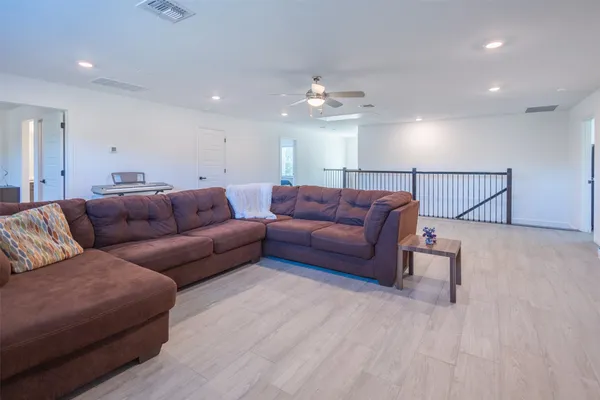 a living room with furniture a ceiling fan and a rug
