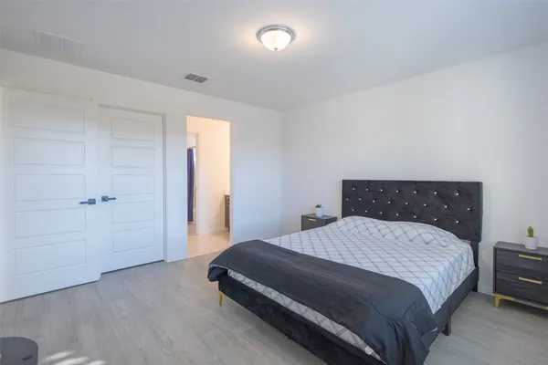 a bedroom with a bed and a night stand