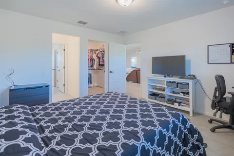 a bedroom with a bed and a television