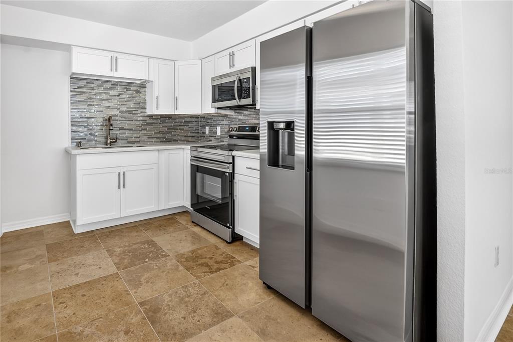 13440 1st Street East Madeira Beach, FL 33708 - Photo 16 of 44 a kitchen with a refrigerator stove and microwave