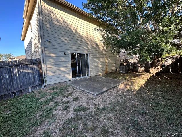 a view of a backyard with wooden fence