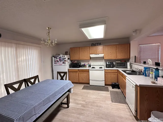 a kitchen with kitchen island granite countertop a stove a sink a dining table and chairs