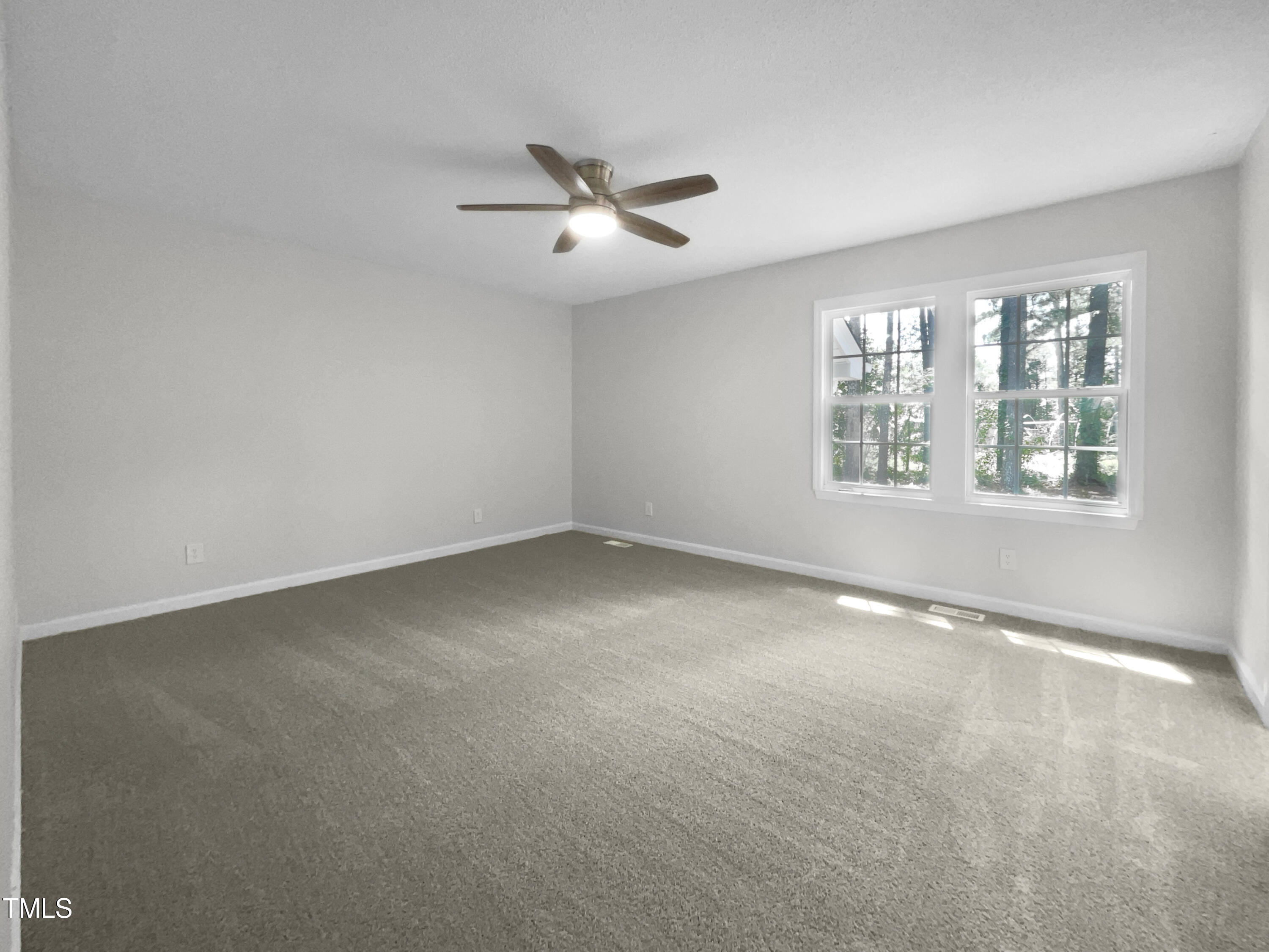 1516 Clayton Road Fuquay-Varina, NC 27526 - Photo 16 of 17 an empty room with windows and chandelier fan