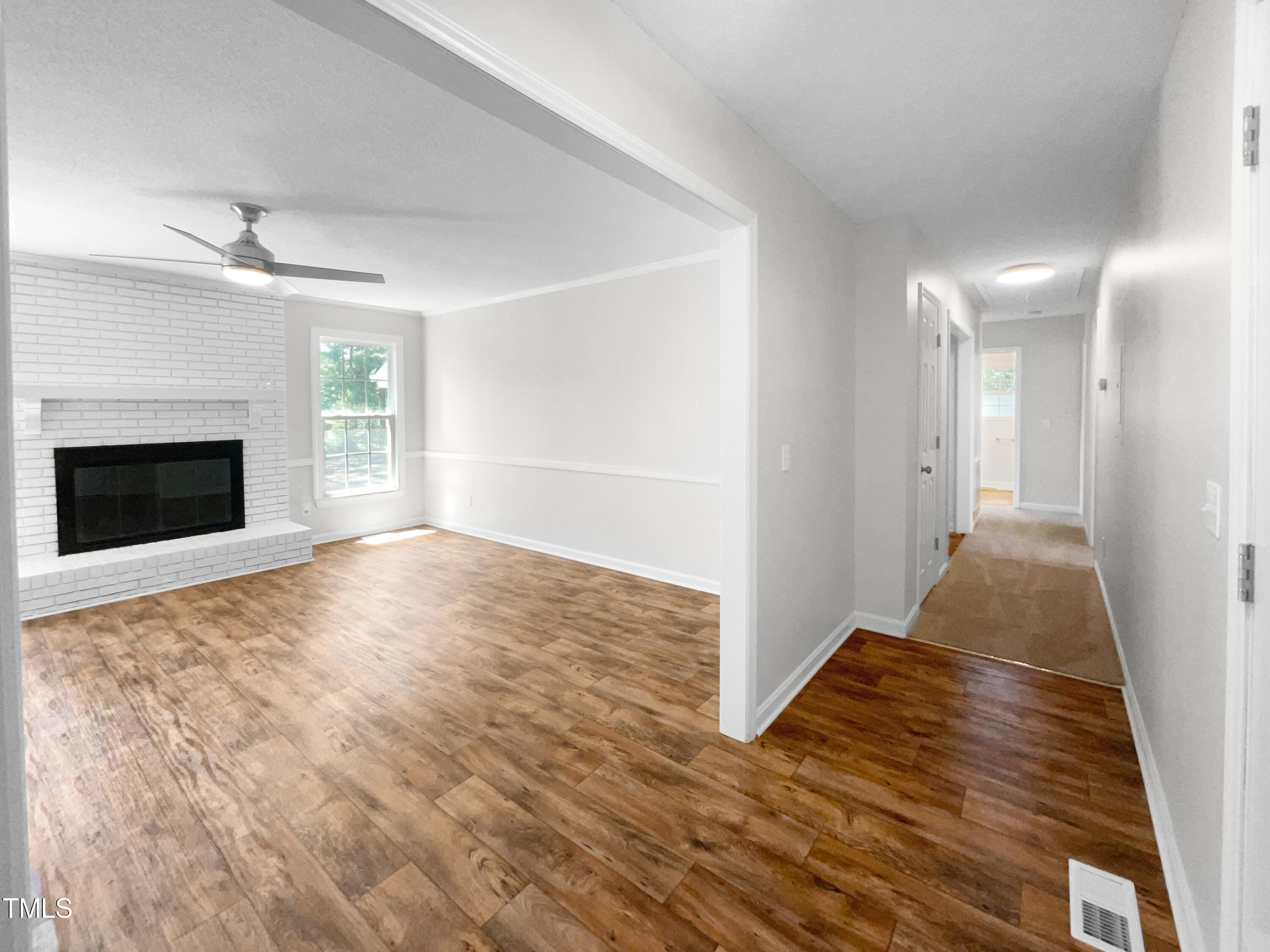 1516 Clayton Road Fuquay-Varina, NC 27526 - Photo 8 of 17 a view of empty room with wooden floor and fireplace