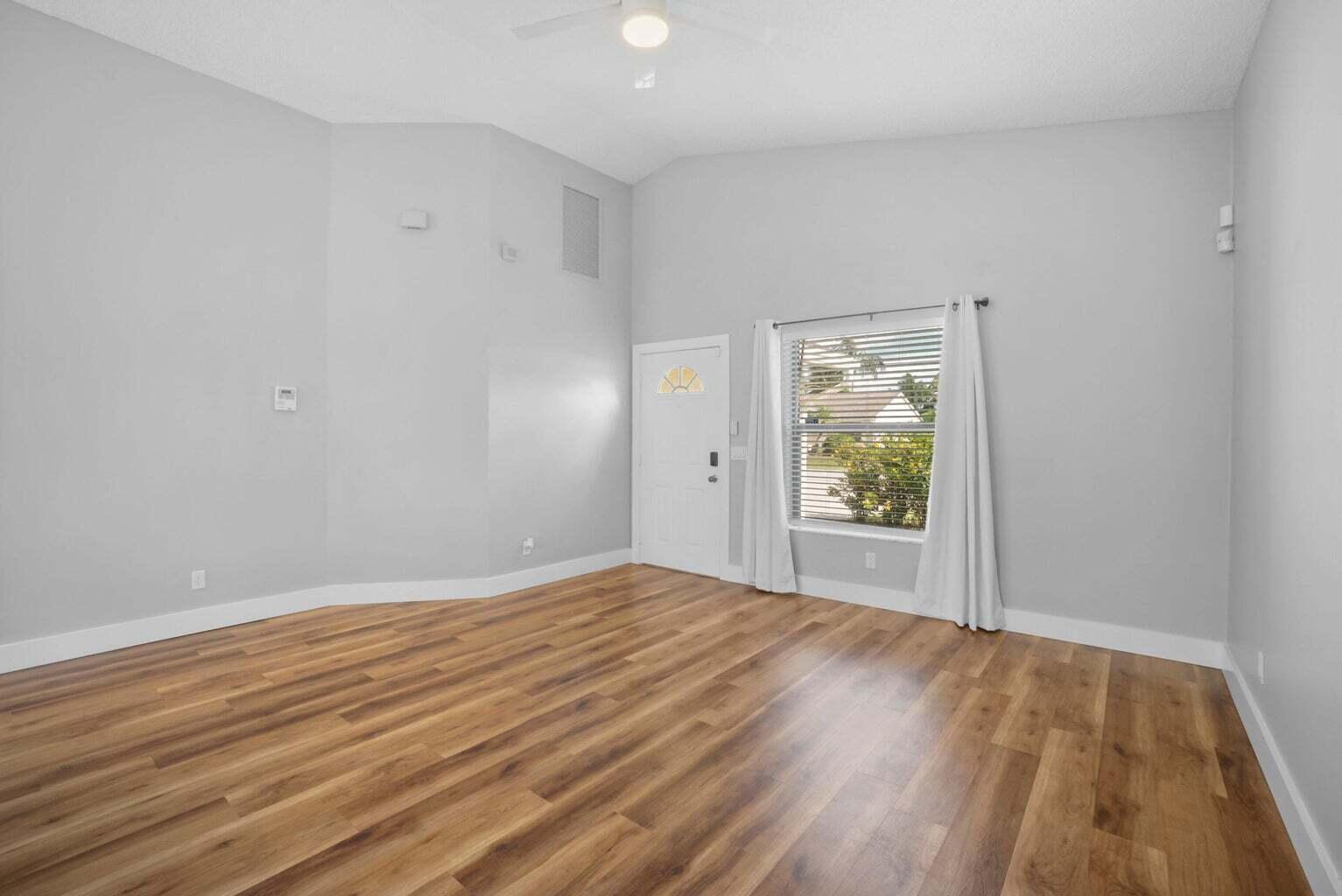 6216 Mullin Street Jupiter, FL 33458 - Photo 4 of 14 a view of an empty room with wooden floor and a window
