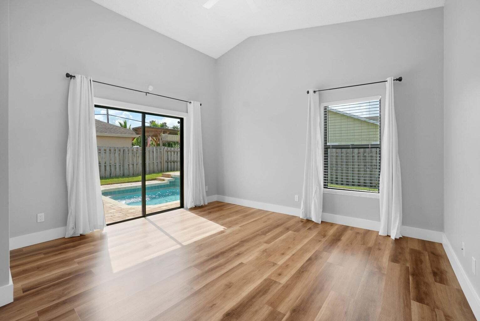 6216 Mullin Street Jupiter, FL 33458 - Photo 6 of 14 a view of an empty room with wooden floor and a window