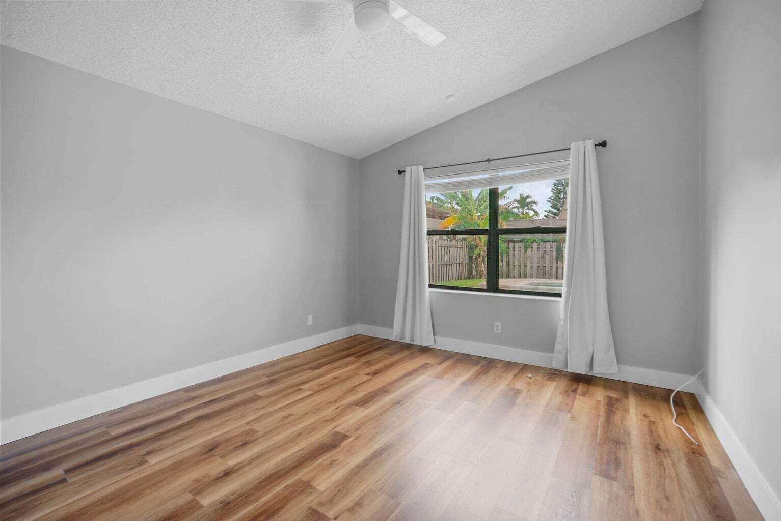 6216 Mullin Street Jupiter, FL 33458 - Photo 7 of 14 wooden floor in an empty room with a window