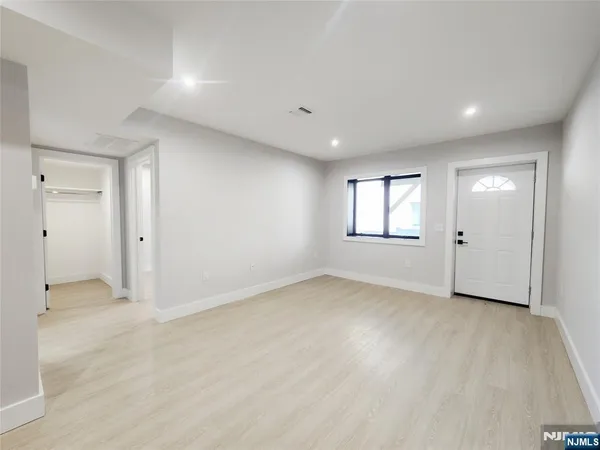 an empty room with windows and closet