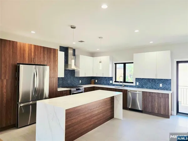 a kitchen with stainless steel appliances a refrigerator sink and cabinets