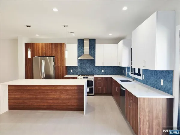 a kitchen with kitchen island granite countertop a sink a counter space and cabinets