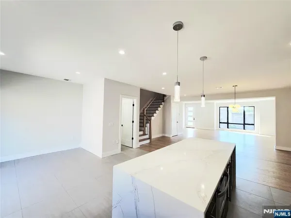 a large room with kitchen island a sink stainless steel appliances and cabinets