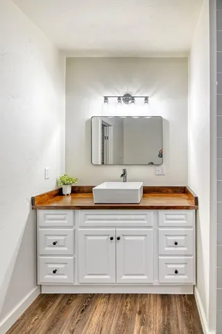 an empty room with wooden floor chandelier fan and windows