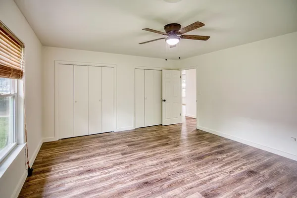 a view of a livingroom with wooden floor and a ceiling fan