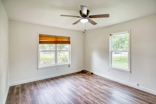 a view of a kitchen with a dishwasher a kitchen island hardwood floor and a ceiling fan