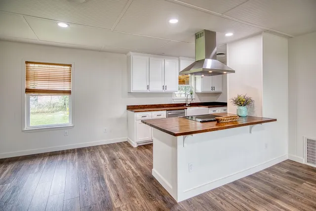 a kitchen with granite countertop white cabinets white appliances and sink