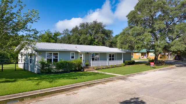 an aerial view of residential house with outdoor space and trees all around