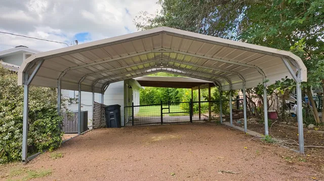 a view of a porch with a table and chairs under an umbrella