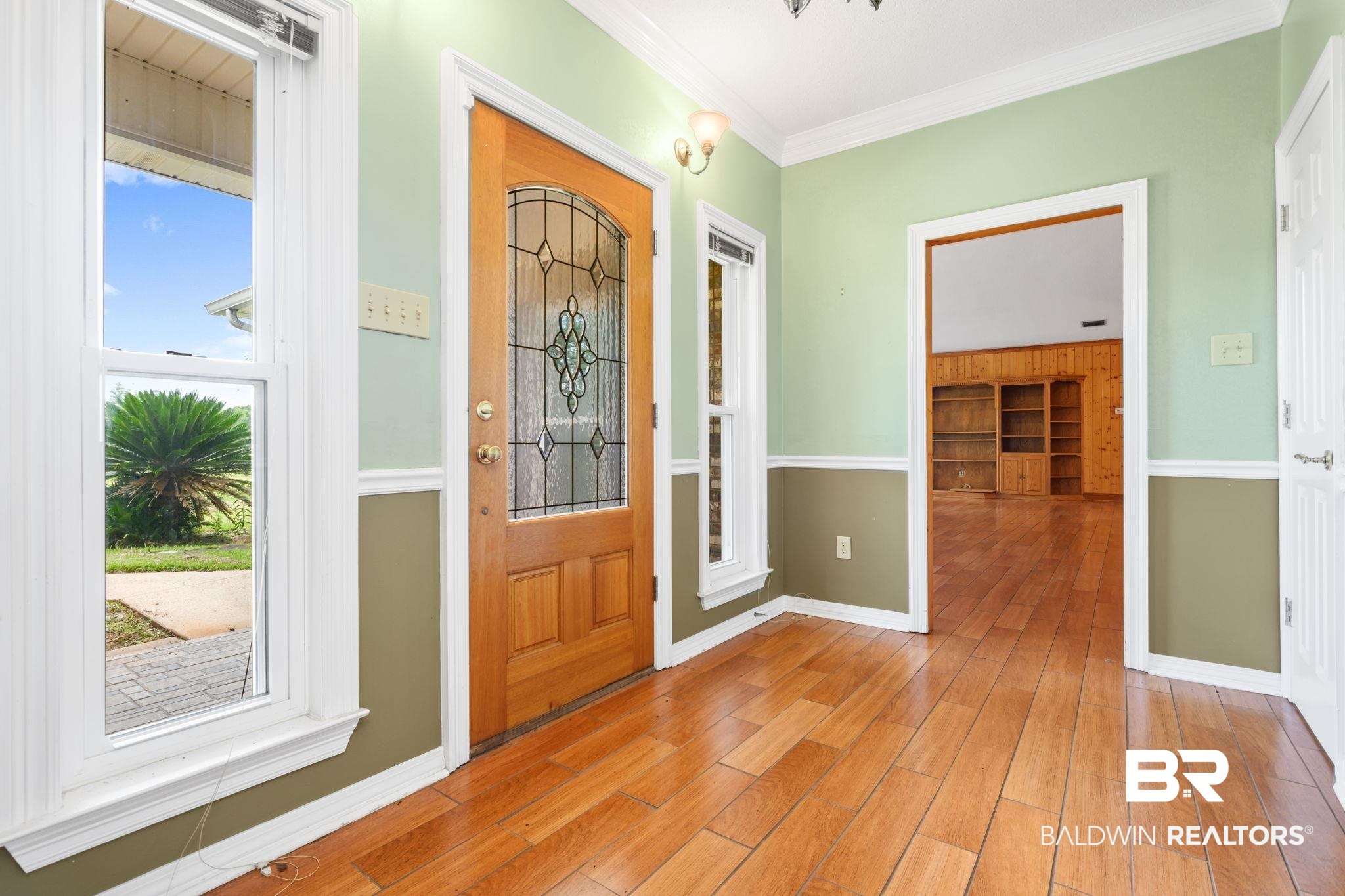 7540 2 Mile Road Irvington, AL 36544 - Photo 11 of 82 Entryway featuring wood-finish flooring, a leaded glass wood-panel door, and decorative wall sconce lighting