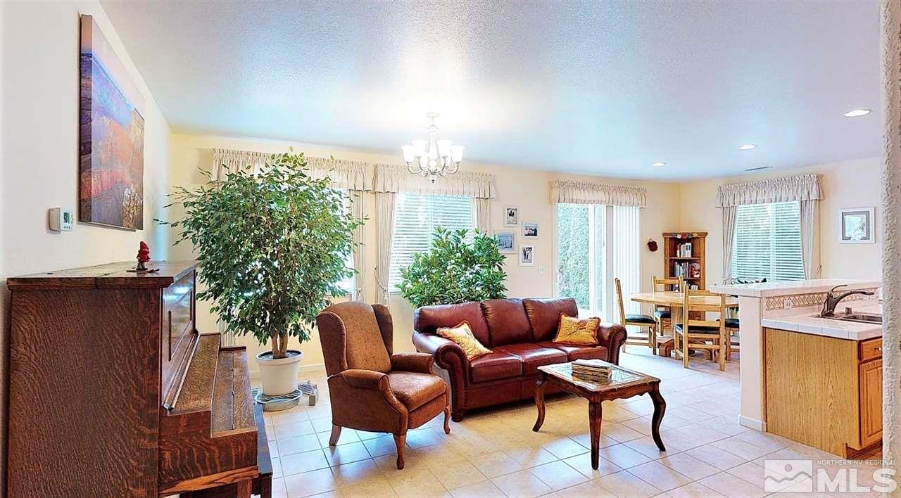 11210 Messina Way Reno, NV 89521 - Photo 3 of 29 a living room with furniture a dining table and a potted plant