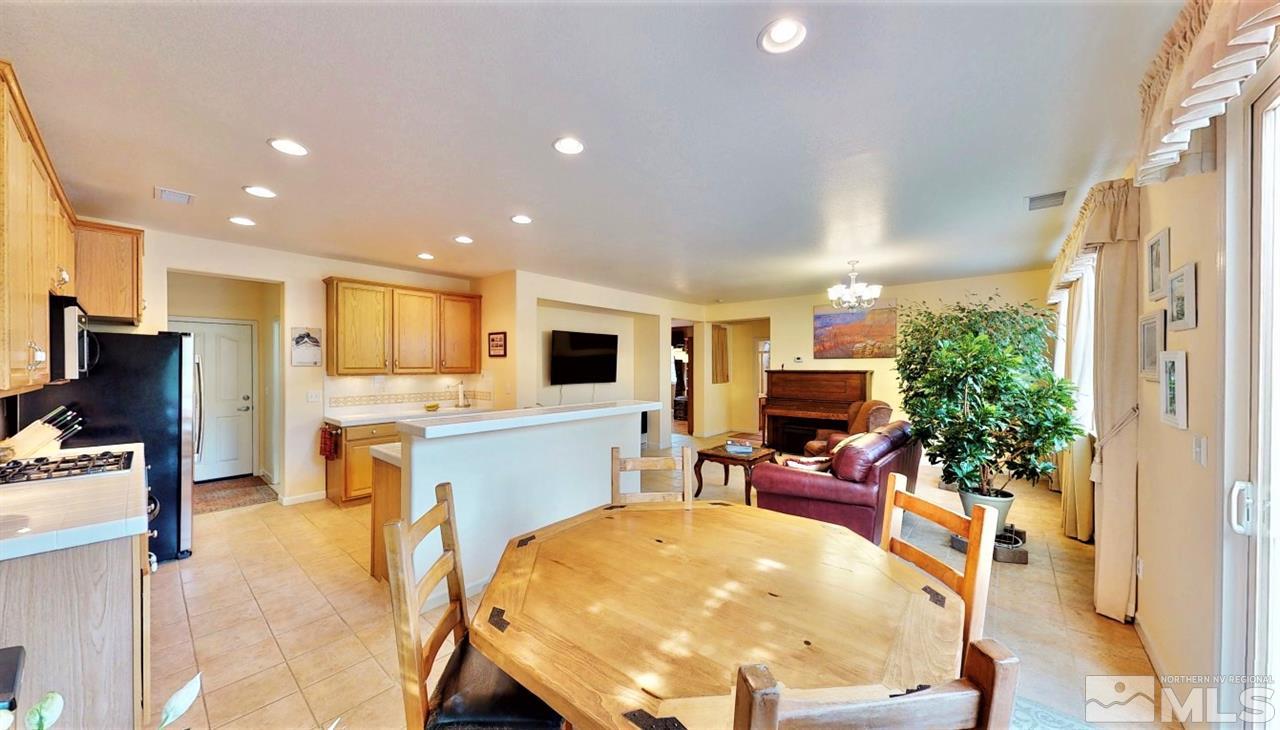 11210 Messina Way Reno, NV 89521 - Photo 5 of 29 a living room with furniture a dining table and chairs with kitchen view