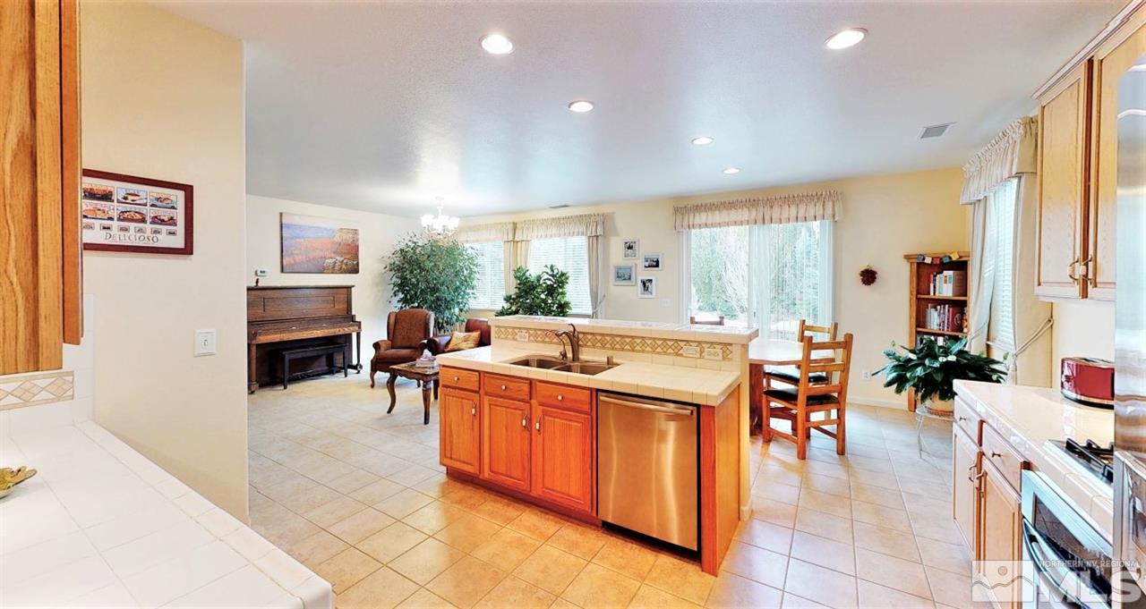 11210 Messina Way Reno, NV 89521 - Photo 6 of 29 a kitchen with stainless steel appliances a stove a sink a counter top space and living room view