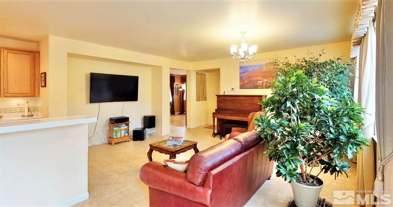11210 Messina Way Reno, NV 89521 - Photo 9 of 29 a living room with furniture a flat screen tv and a fireplace