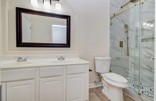 a bathroom with a toilet sink vanity and mirror