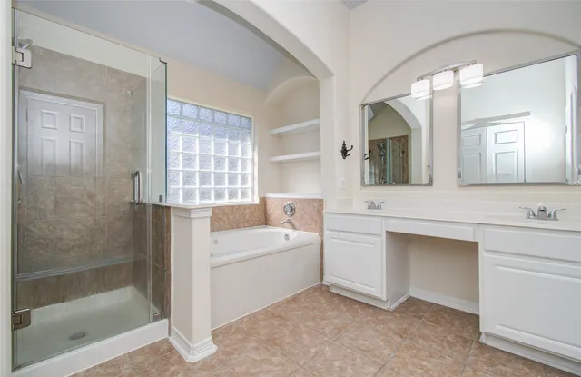 a bathroom with a double vanity sink mirror and bathtub
