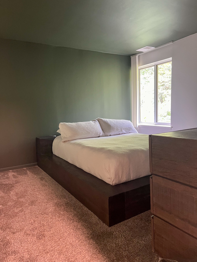 5880 Forest View Road, Unit F Lisle, IL 60532 - Photo 11 of 39 a bed sitting in a bedroom next to a window
