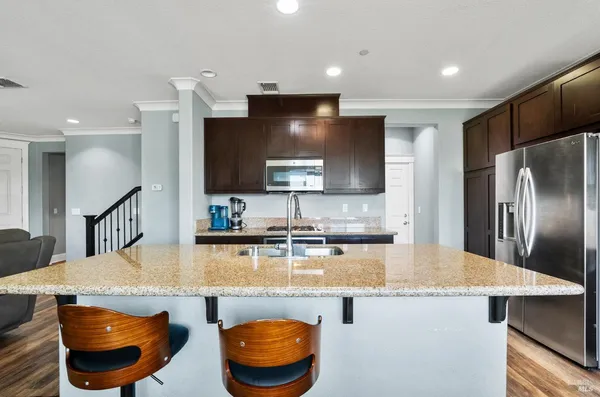 a kitchen with stainless steel appliances granite countertop a sink a stove and a refrigerator