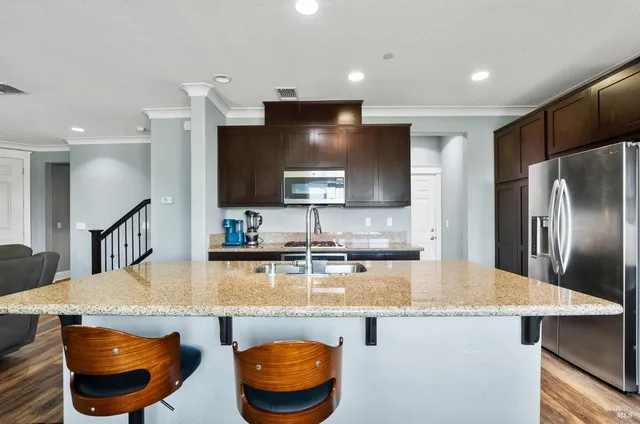 a kitchen with stainless steel appliances granite countertop a sink a stove and a refrigerator