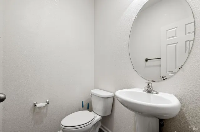 a bathroom with a sink a toilet and a mirror