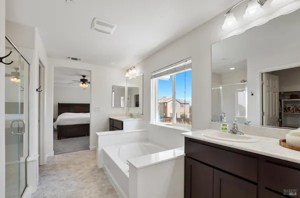 a en suite bathroom with a double vanity sink a mirror and a shower