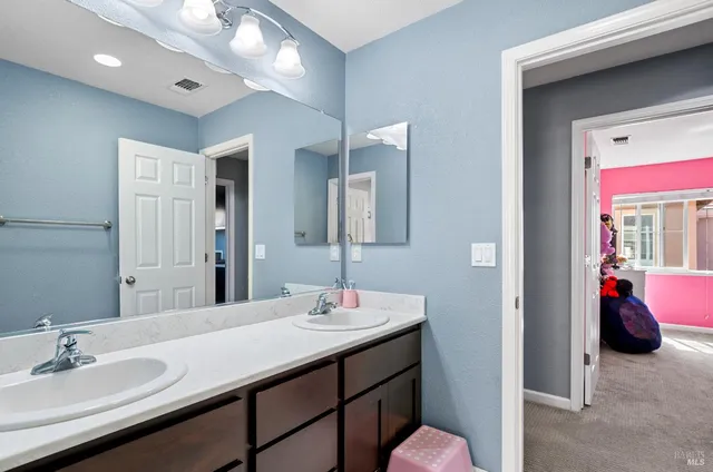 a en suite bathroom with a double vanity sink and a mirror