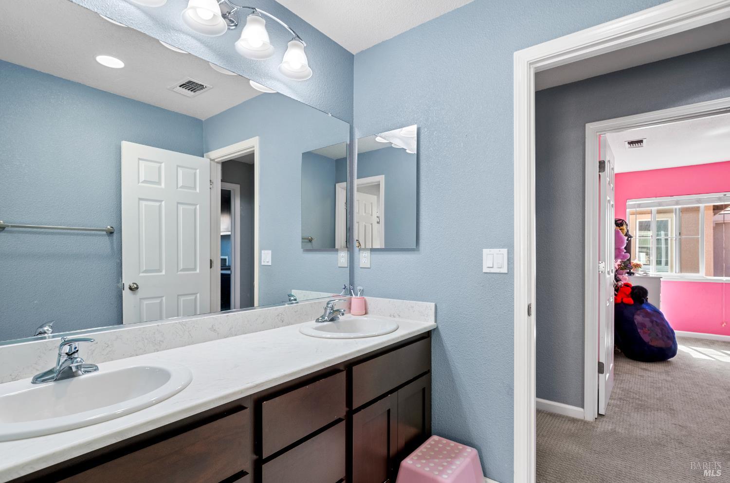 5311 Gramercy Circle Fairfield, CA 94533 - Photo 38 of 43 a en suite bathroom with a double vanity sink and a mirror