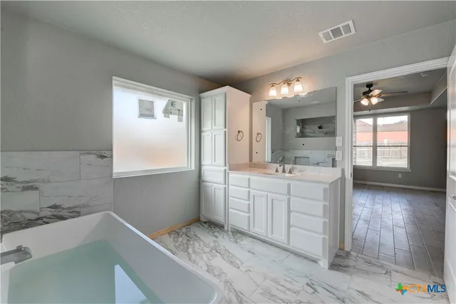 a bathroom with a double vanity sink mirror and shower