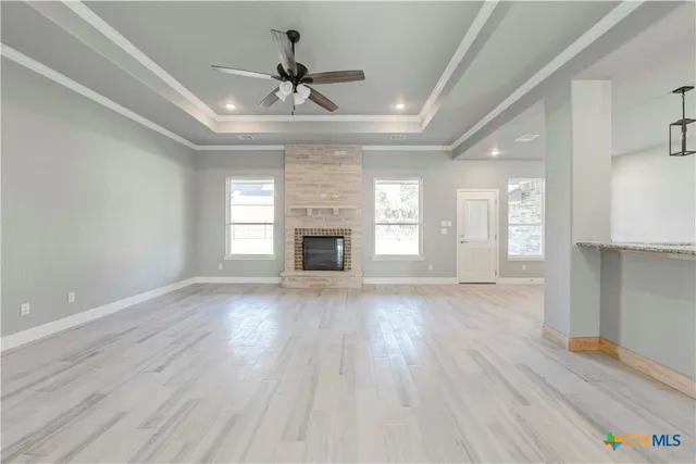 a view of an empty room with a window and fireplace