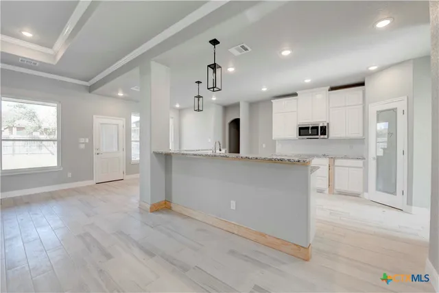 a large kitchen with stainless steel appliances granite countertop a lot of counter space and wooden floors