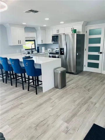 a kitchen with stainless steel appliances a refrigerator sink and cabinets