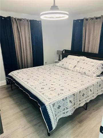 a bed sitting in a bedroom next to a wooden cabinet