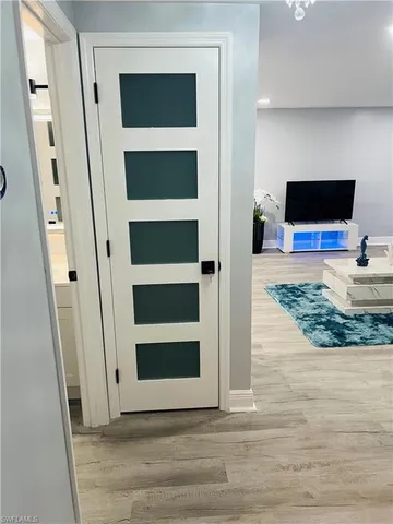 a view of a livingroom with wooden floor and a flat screen tv